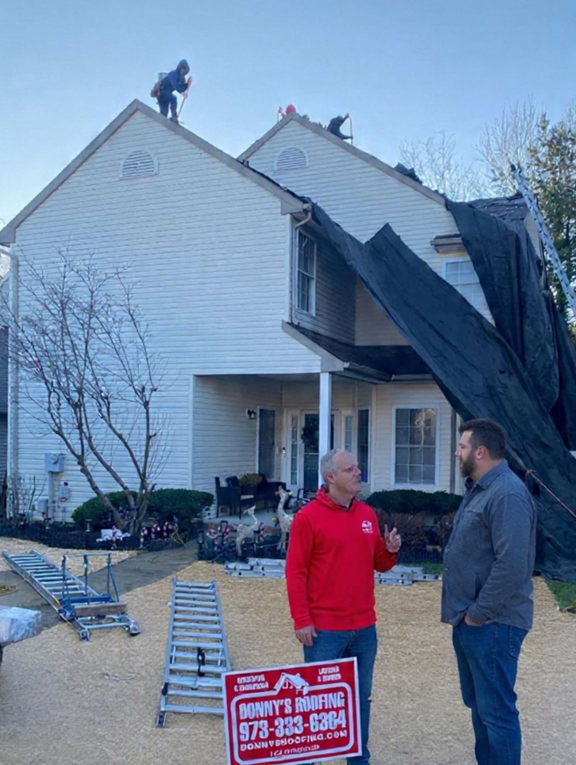 Donny's Home Improvement project manager reviewing a roof replacement plan with a homeowner